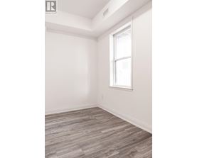 A room with a window and wooden flooring.