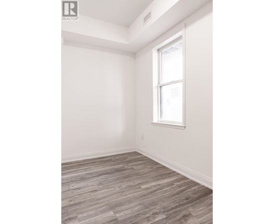 A room with a window and wooden flooring.