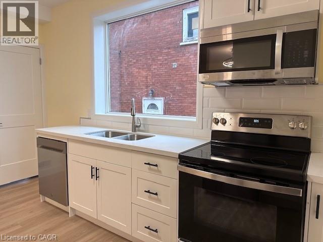 A kitchen with a black stove top oven and white cabinets.