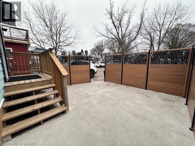 A parking lot with a wooden fence and a building in the background.