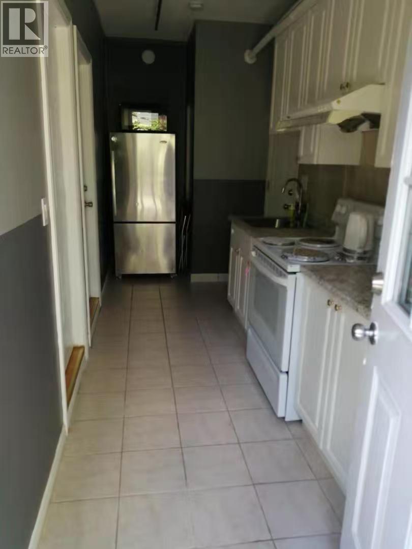A kitchen with white cabinets and a stainless steel refrigerator.
