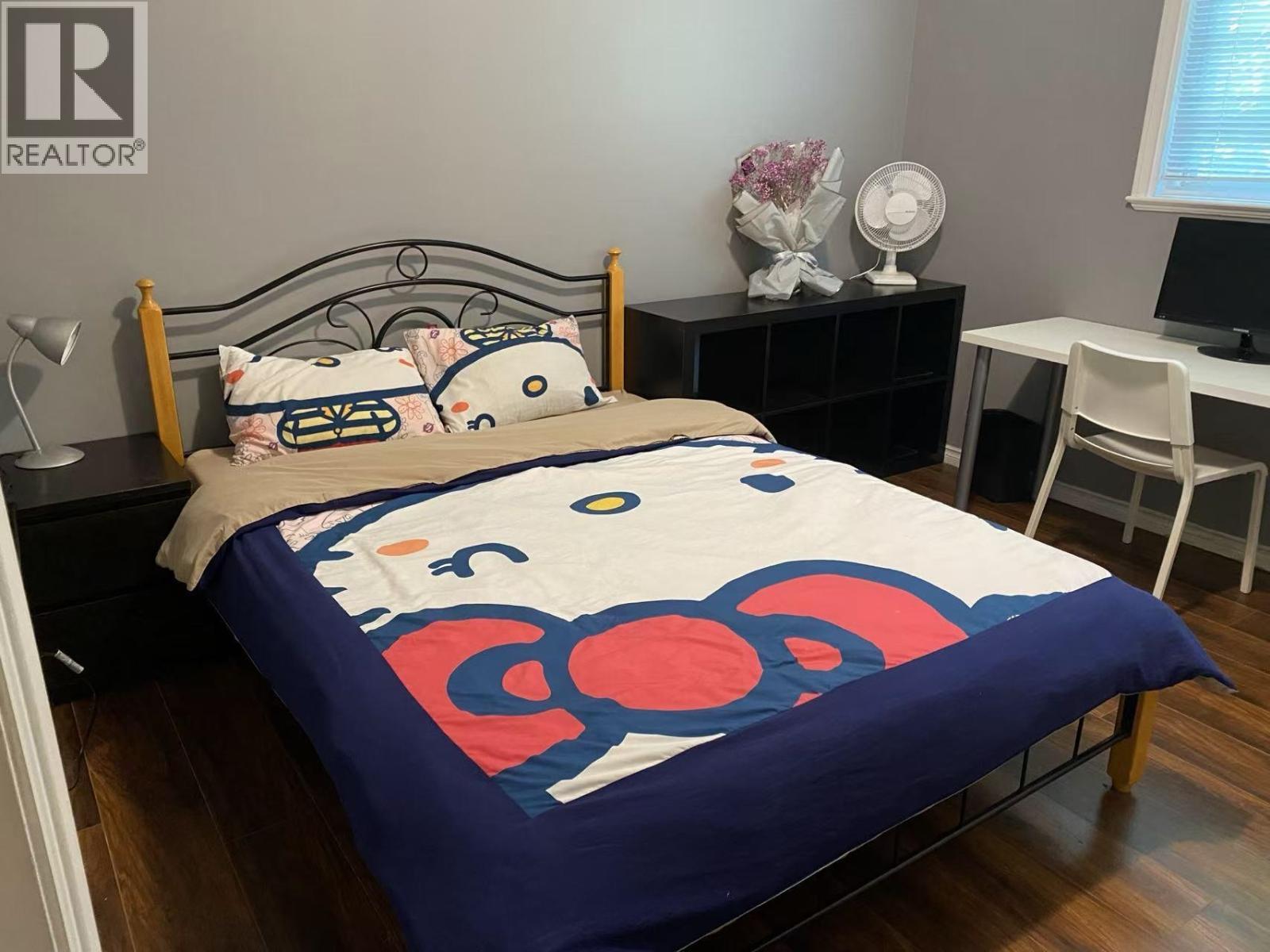 A bed with a blue comforter and pillows in a room.