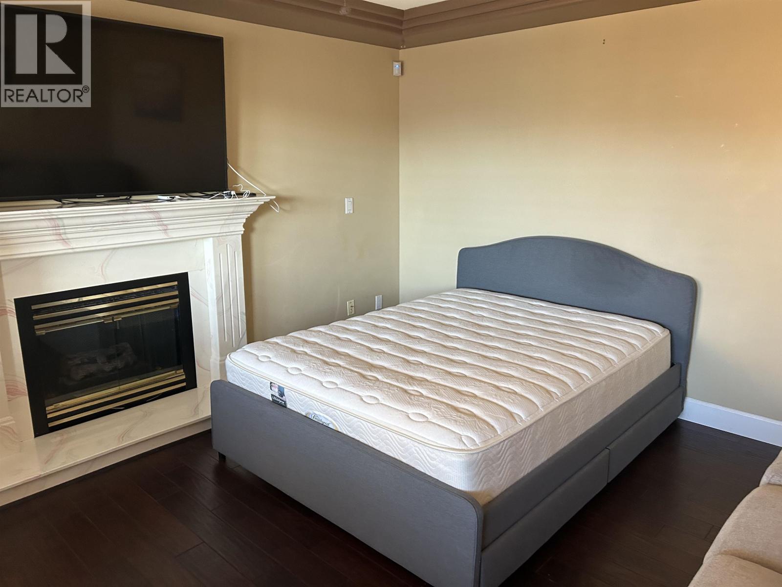 A bed with a mattress in a room with a fireplace.