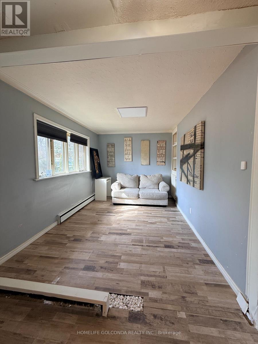 A living room with a white couch and wooden flooring.