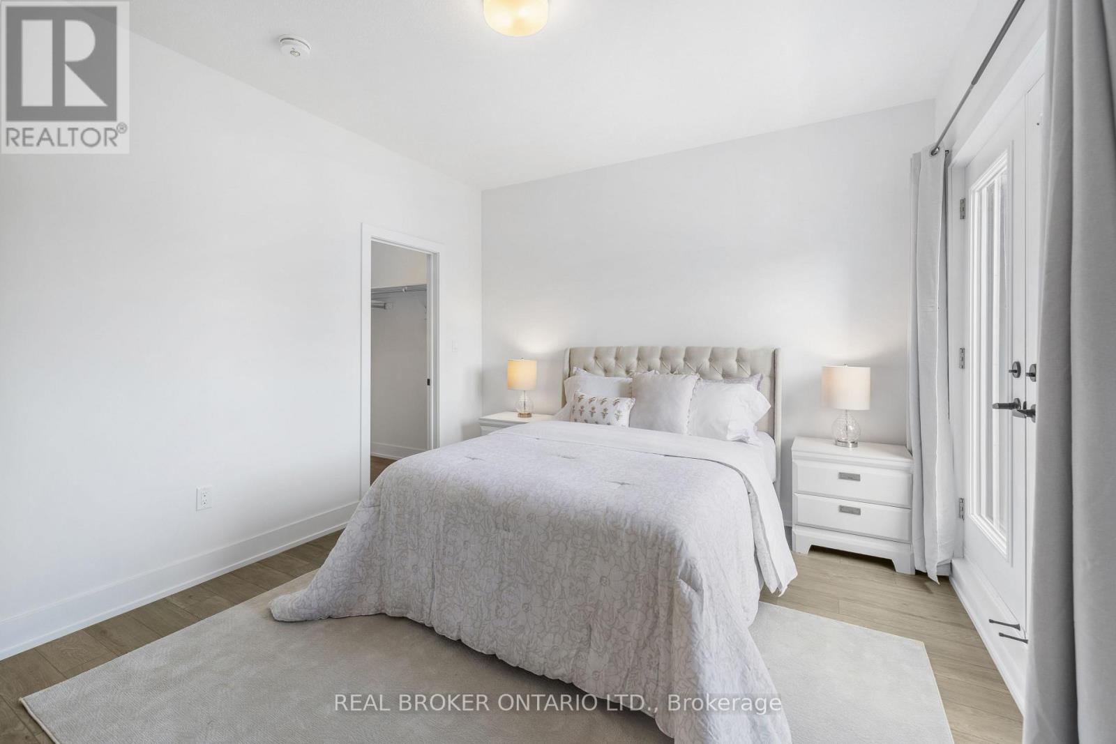 A bedroom with a large bed and two nightstands.