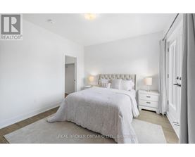 A bedroom with a large bed and two nightstands.