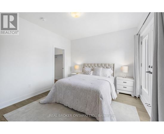 A bedroom with a large bed and two nightstands.