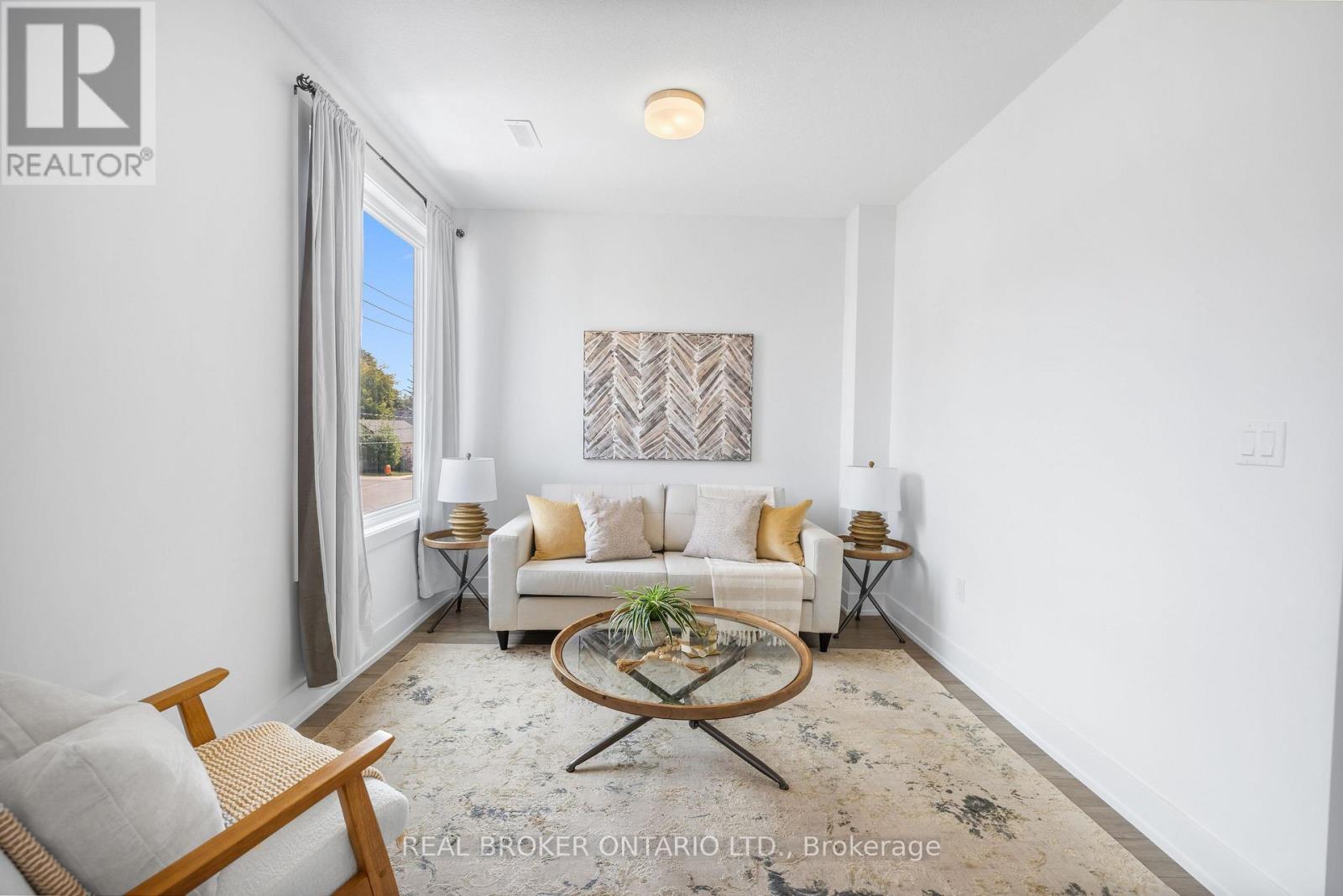 A living room with a white couch, a coffee table, and a painting on the wall.