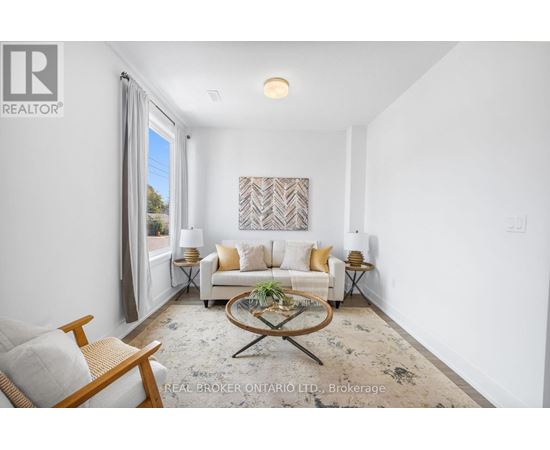 A living room with a white couch, a coffee table, and a painting on the wall.