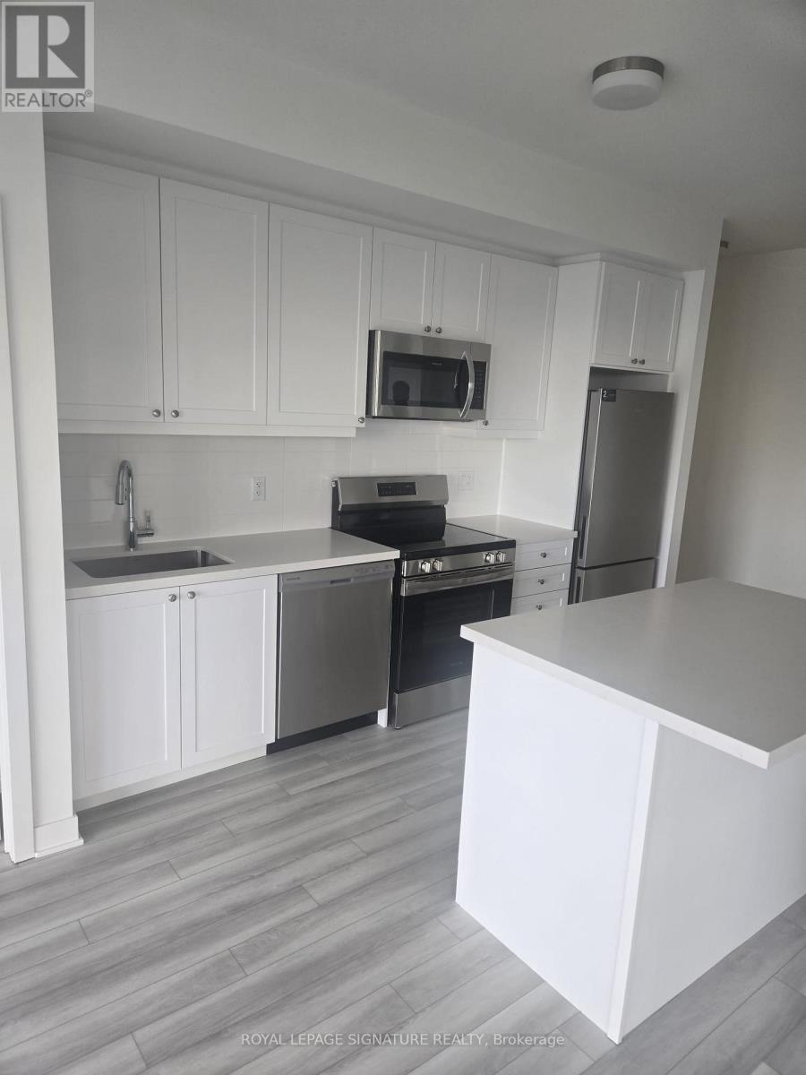 A kitchen with white cabinets and a grey floor.