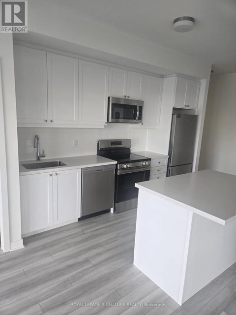 A kitchen with white cabinets and a grey floor.