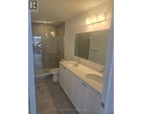 A white bathroom with a sink, toilet and shower.
