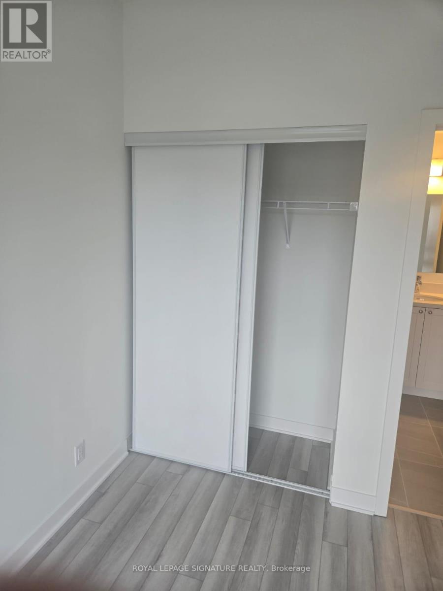 A white sliding door in a room with wooden flooring.