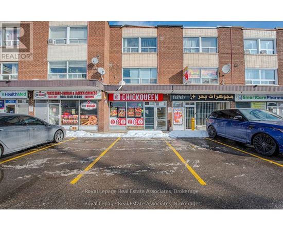 A parking lot with a car and a building with a Chick-fil-A sign.
