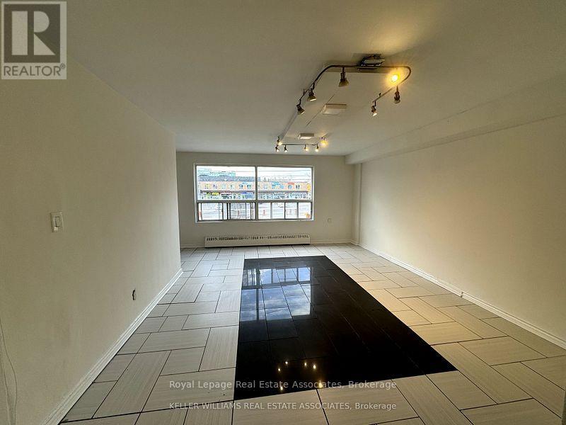 A room with a large window and a black floor mat.