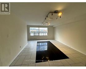 A room with a large window and a black floor mat.