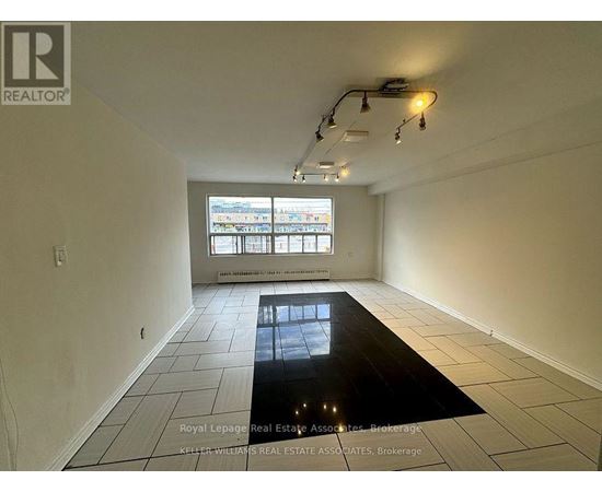 A room with a large window and a black floor mat.