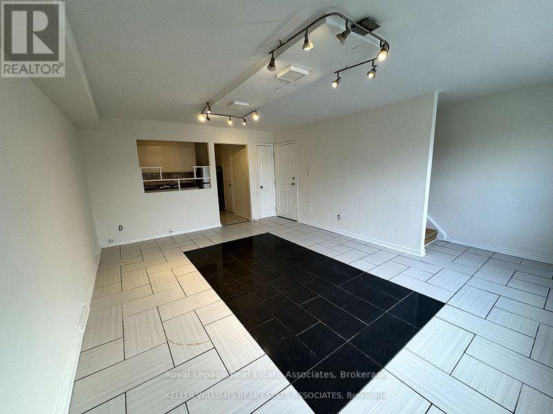 A spacious room with a black rug in the middle and white walls.