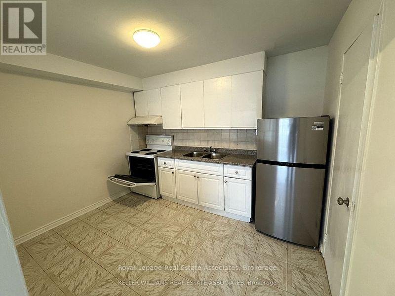 A kitchen with white cabinets and a stainless steel refrigerator.