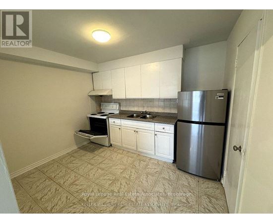 A kitchen with white cabinets and a stainless steel refrigerator.