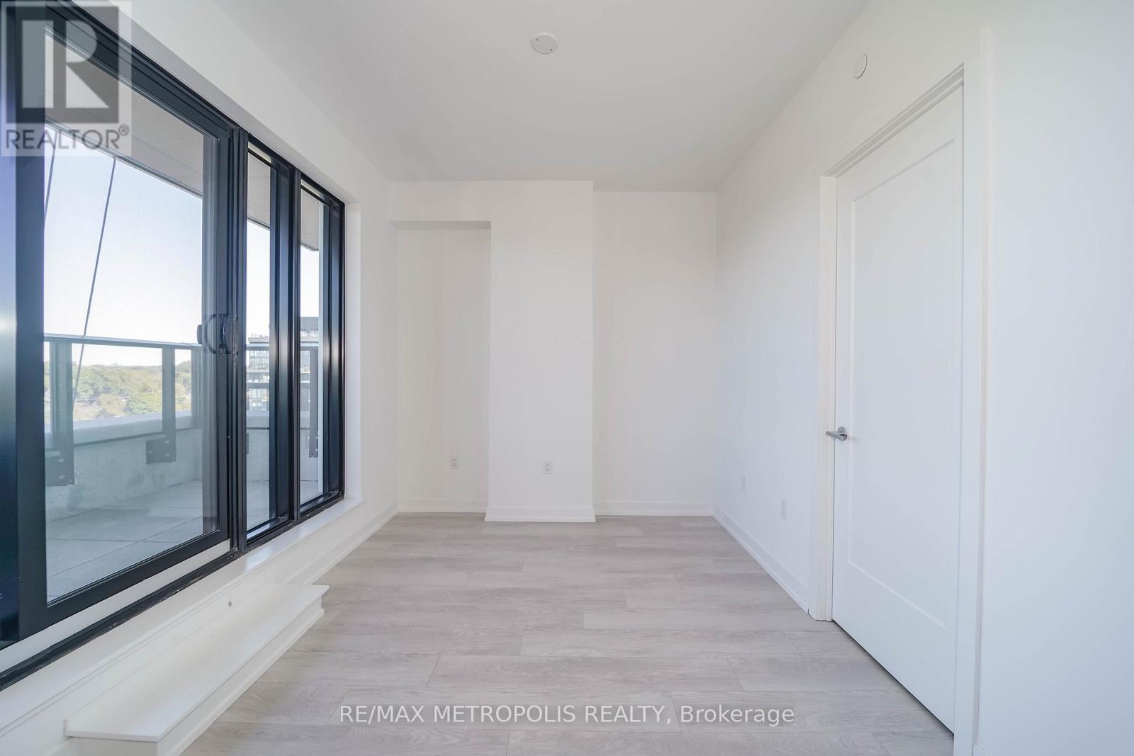 A spacious room with a large window and a door.