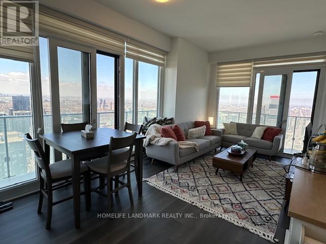 A living room with a dining table and a couch with a view of the city.