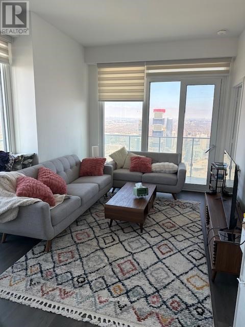 A living room with a dining table and a couch with a view of the city.