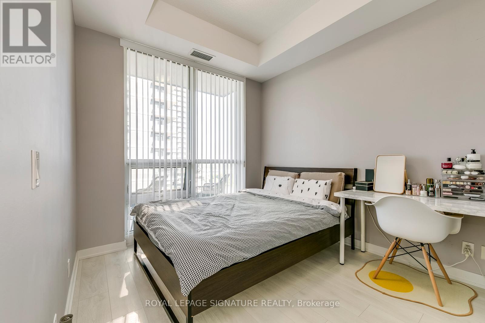 A bedroom with a bed, desk, and chair.