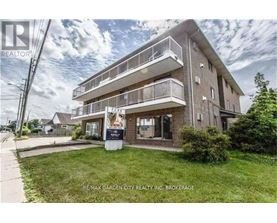 A building with a balcony and a sign that says RE/MAX GARDEN CITY REALTY INC. BROKERAGE.