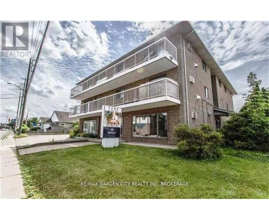 A building with a balcony and a sign that says RE/MAX GARDEN CITY REALTY INC. BROKERAGE.