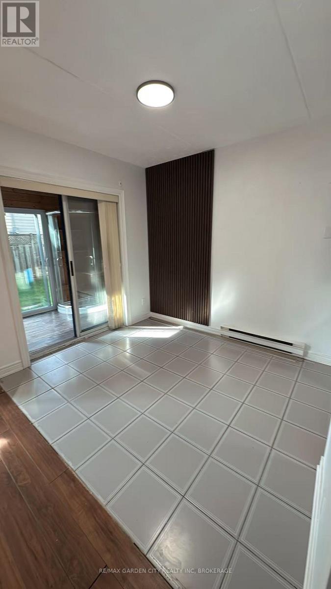 A spacious room with a sliding glass door and a tiled floor.