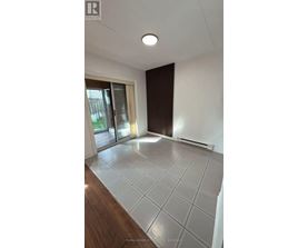 A spacious room with a sliding glass door and a tiled floor.