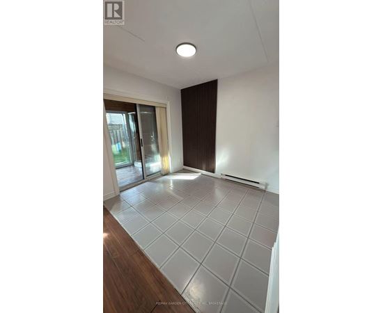 A spacious room with a sliding glass door and a tiled floor.
