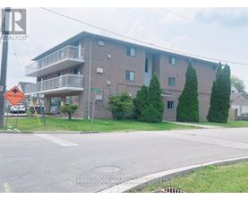 Apartment building with a sign that says RE/MAX Garden City Realty.