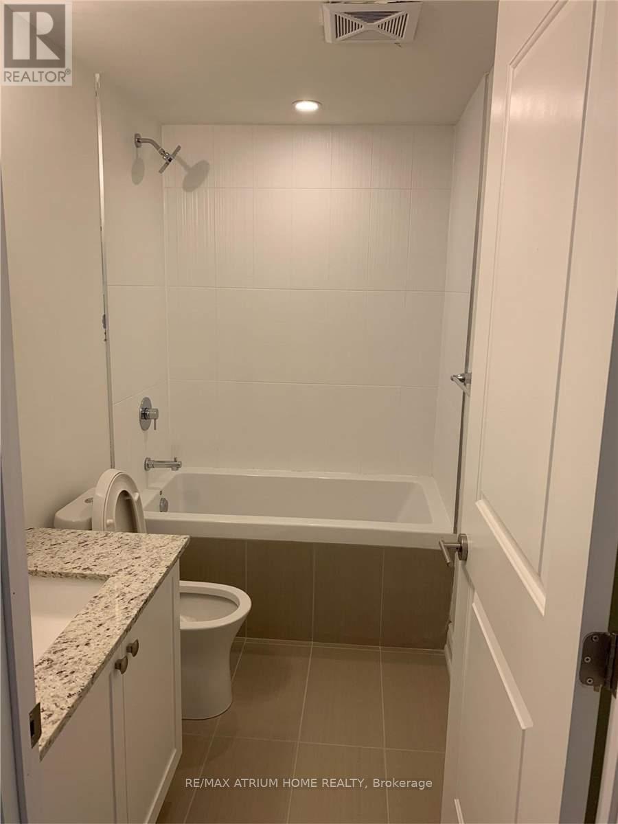 A white bathroom with a tub, toilet and sink.