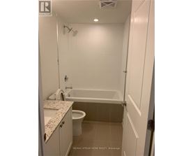 A white bathroom with a tub, toilet and sink.