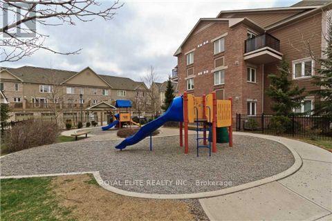 A playground with a blue slide and orange and yellow climbing frame in front of apartment buildings.