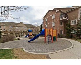 A playground with a blue slide and orange and yellow climbing frame in front of apartment buildings.