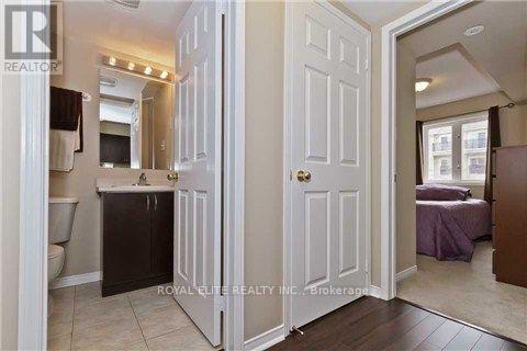 A white door is open to a bedroom with a bed and a dresser.