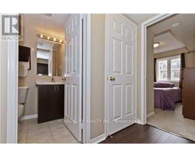 A white door is open to a bedroom with a bed and a dresser.