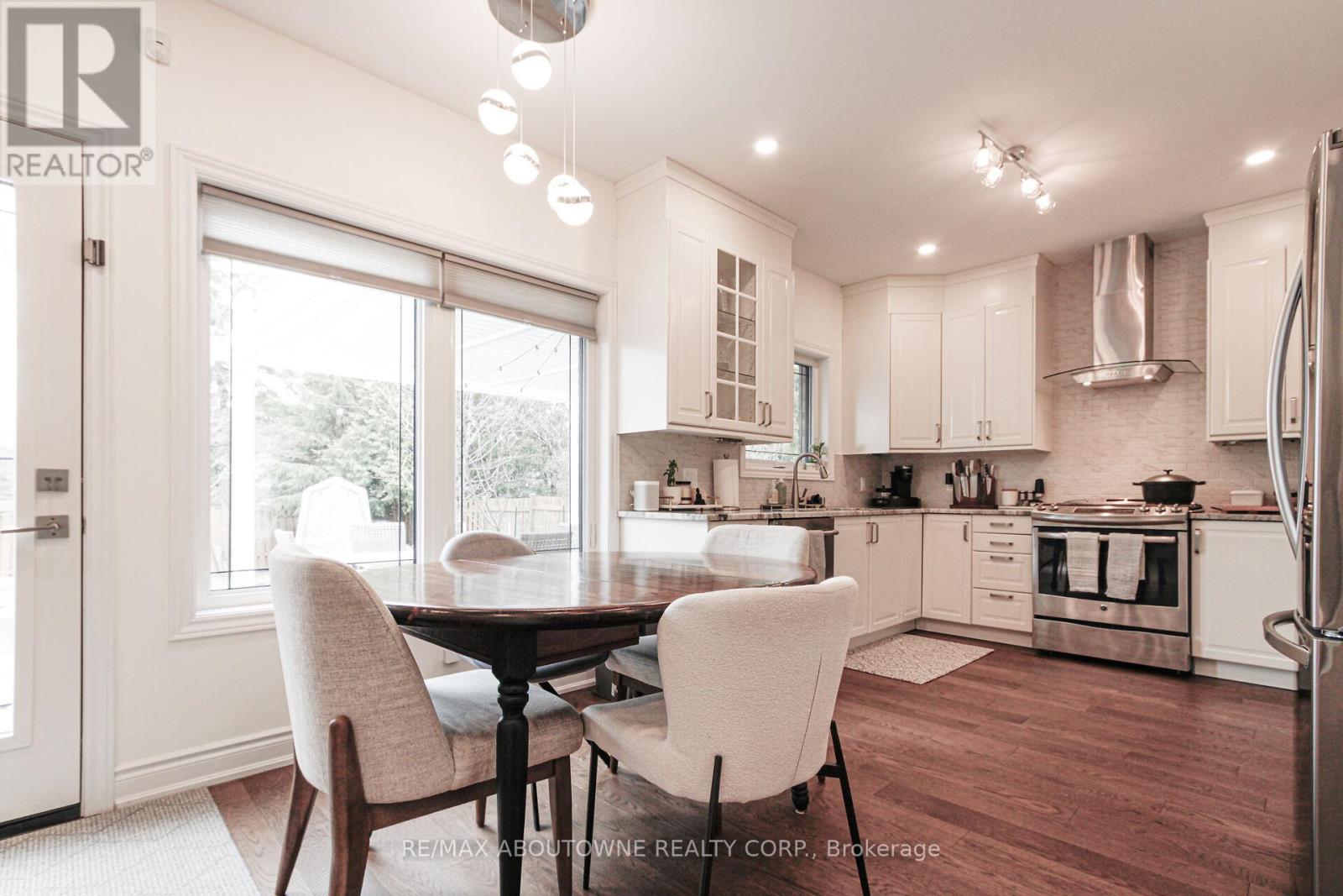 A well-lit kitchen with a dining table and chairs.
