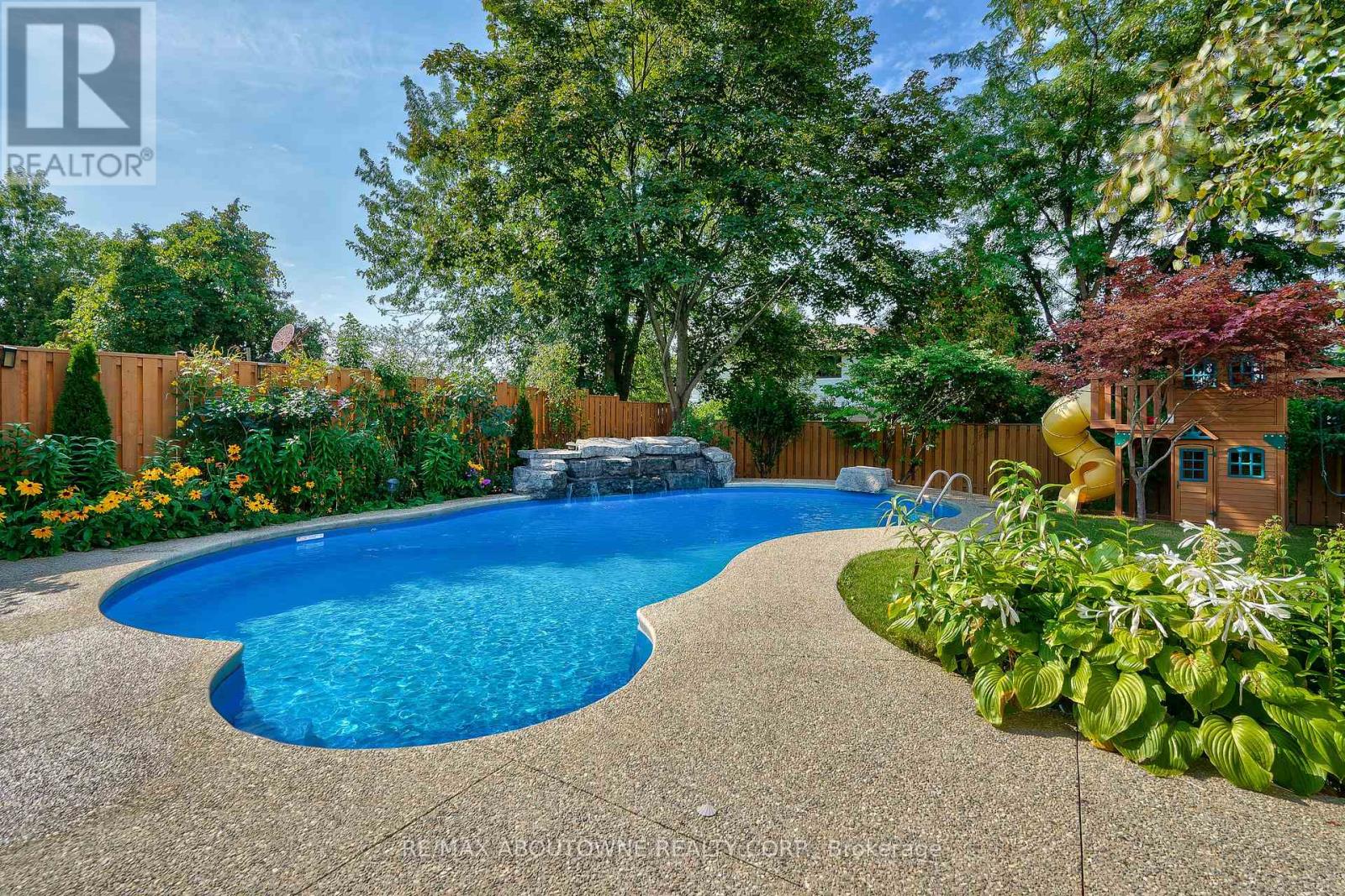 A backyard with a blue pool and a small wooden house.