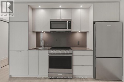 A modern kitchen with white cabinets and stainless steel appliances.