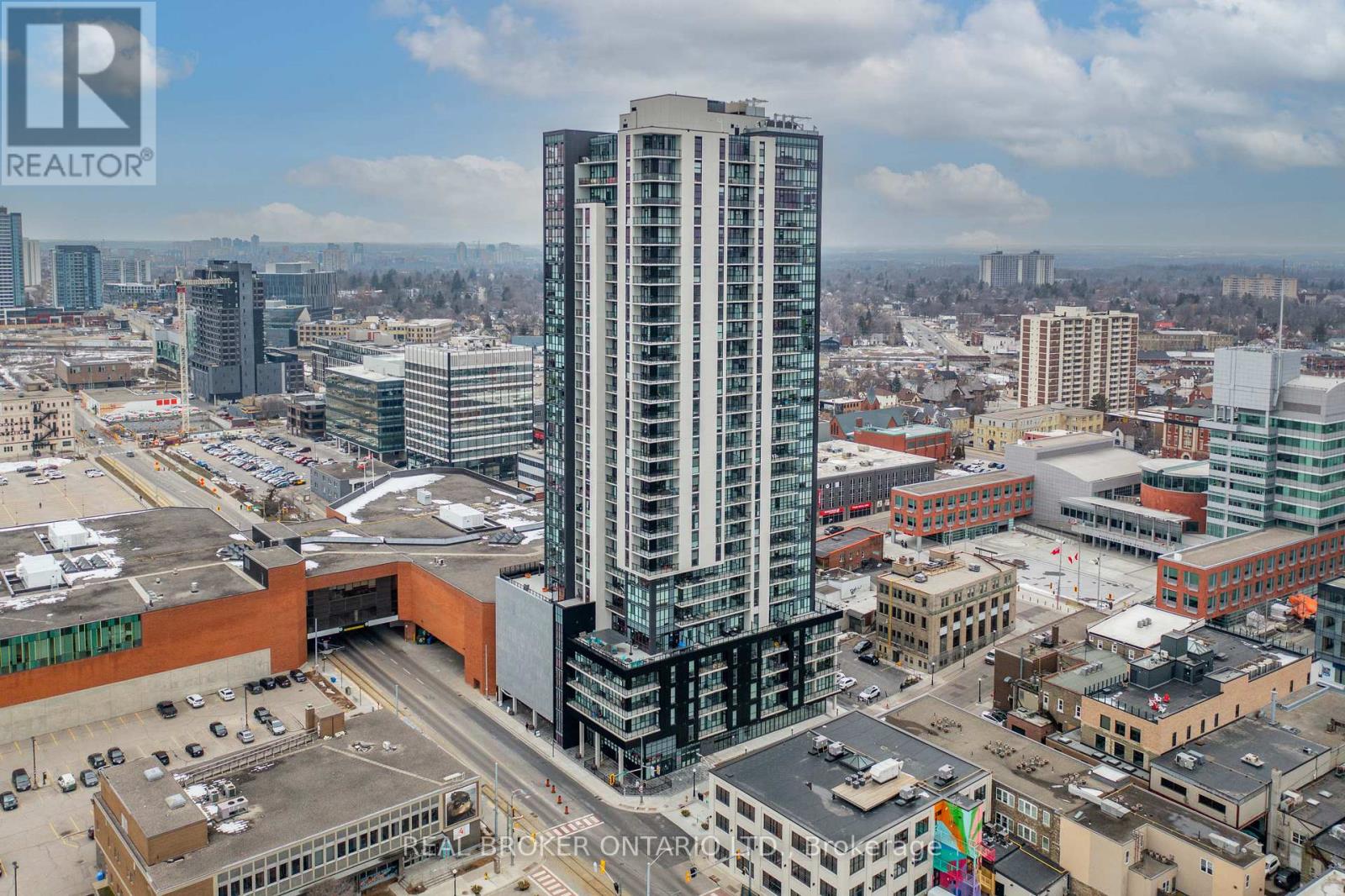 A cityscape with a tall building in the center and a parking lot in the foreground.