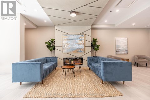 A living room with a blue couch and a rug.