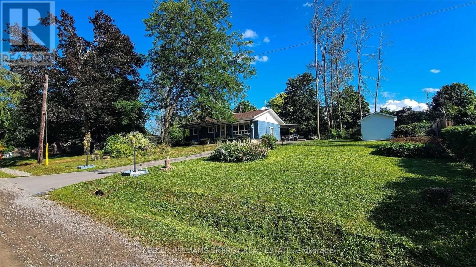 A house is surrounded by a green lawn and trees.