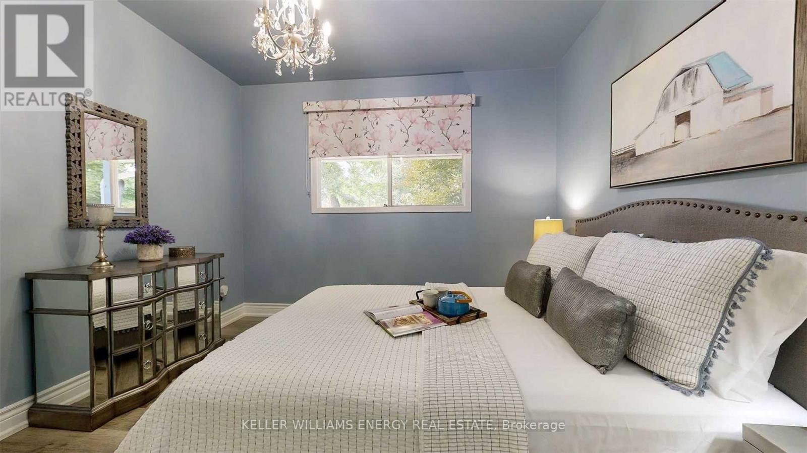A bedroom with a large bed and a chandelier.