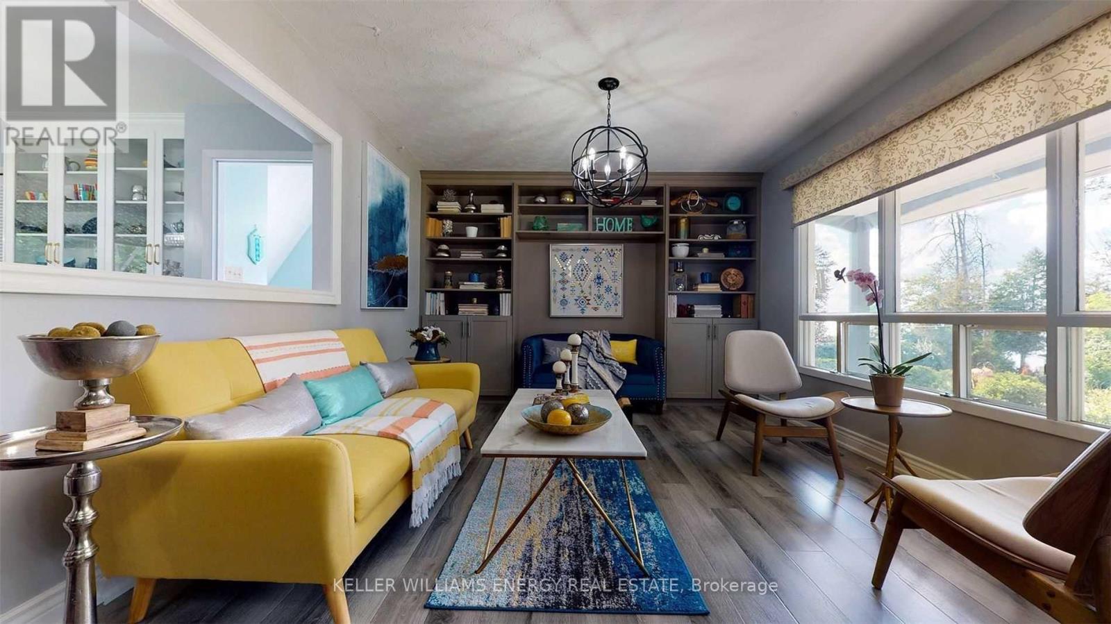 A living room with a yellow sofa and a wooden coffee table.