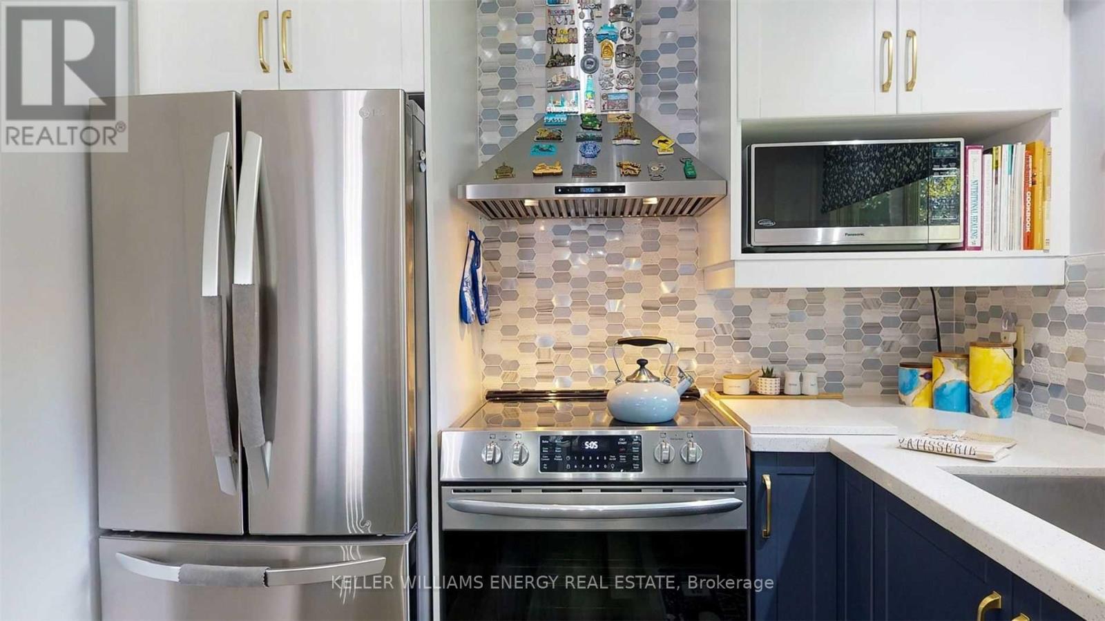 A modern kitchen with a stainless steel refrigerator and a stove top oven.