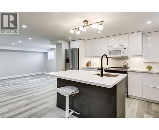 A modern kitchen with white cabinets and a black island.
